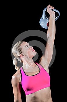 Muscular woman lifting heavy kettlebell