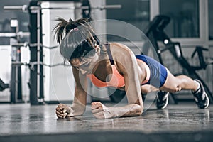 Muscular woman on a plank position.