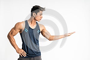 Muscular young Asian man in sportswear stands sideways with present something on his hand