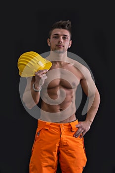 Muscular young construction worker shirtless with hardhat