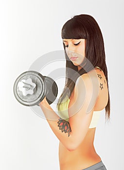 Muscular young girl with dumbbells