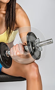 Muscular young girl with dumbbells