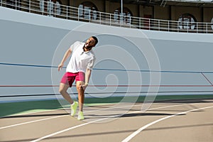 Muscular young male runner suffering from kneecap injury