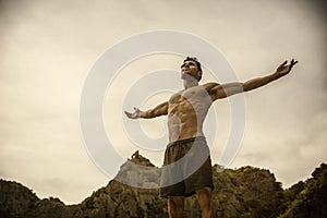 Muscular young man on the beach enjoying freedom