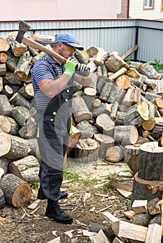 Muscular young man chopping logs