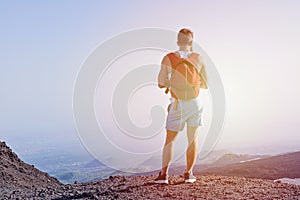 Muscular young man climbed up the mountain