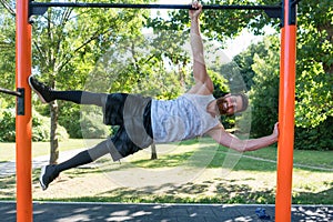 Muscular young man doing bodyweight exercises in a modern fitness park