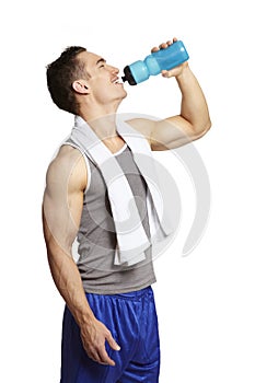 Muscular young man drinking in sports outfit