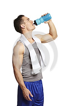 Muscular young man drinking in sports outfit