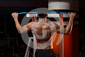 Muscular Young Man Exercising In Gym