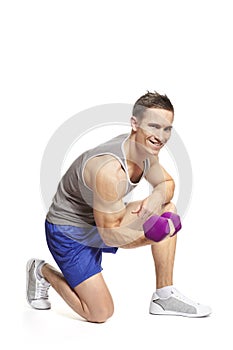 Muscular young man exercising in sports outfit