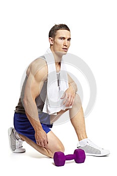 Muscular young man exercising in sports outfit