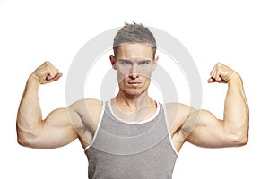 Muscular young man flexing arm muscles in sports outfit