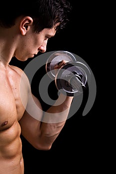 Muscular young man lifting dumbbells