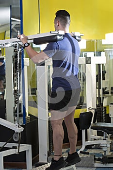 Muscular young man performing leg exercises on the machine.