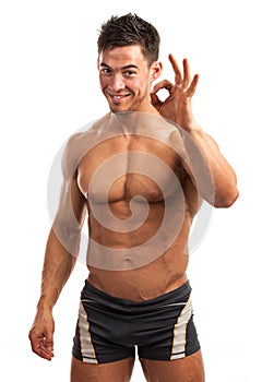 Muscular young man showing the ok sign