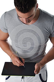 Muscular young man sketching on digital graphic tablet