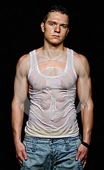 Muscular young man in the white wet t-shirt