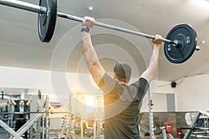 Muscular young man working with barbell heavy weights in training gym. Sport, bodybuilding, athlete, weightlifting, workout