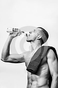 Muscular young man after a workout drinking bottle of water