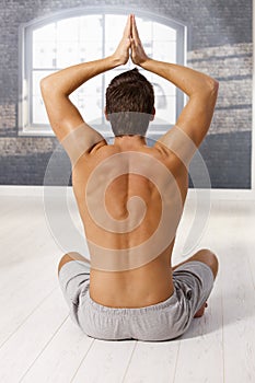 Muscular young man in yoga exercise