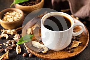 Mushroom coffee in a cup and coffee beans, trendy drink on a stone background. Healthy organic energizing adaptogen