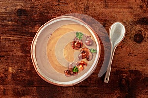 Mushroom cream soup, shot from the top on a dark rustic wooden table