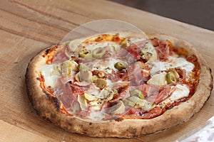 Mushroom and ham pizza rest on a wooden table with copy space for your text