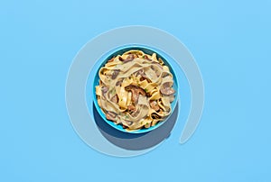 Mushroom pasta dish, above view on a blue background