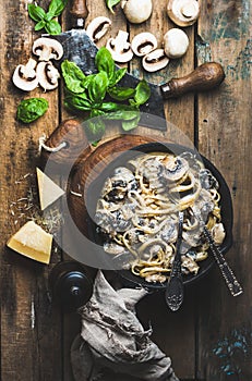 Mushroom pasta spaghetti in iron pan served with parmesan, basil