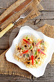 Mushroom pasta with vegetables on a plate. Homemade pasta with roasted mushrooms, red pepper and green onions. Vegetarian dish