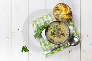 Mushroom soup with a bread roll and parsley