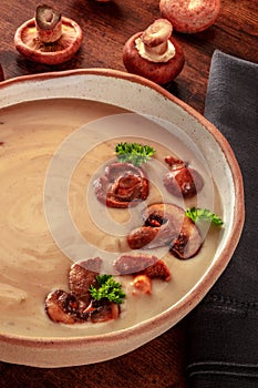 Mushroom soup with ingredients, on a rustic wooden table