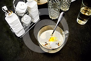 Mushroom soup, glasses, custers and containers on black background. photo