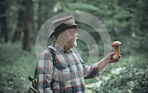 Mushrooming in forest, Grandfather hunting mushrooms over summer forest background. Senior mushroomer. Spring and