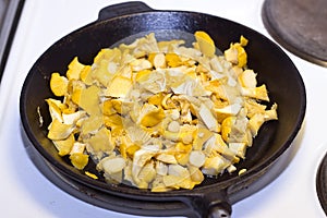 Mushrooms being fried in an old cast iron frying pan