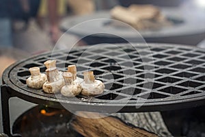 Mushrooms champignons fry on a massive grill