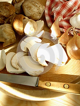 Mushrooms on the cutting board with shallots, onions and garlic