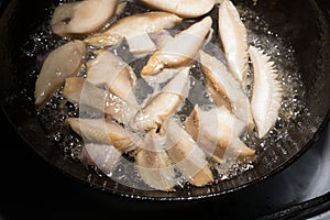 Mushrooms are fried in boiling oil in a pan