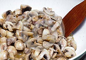 Mushrooms are fried in a pan.