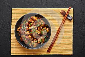 Mushrooms Manchurian dry in black bowl at dark slate background