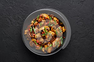 Mushrooms Manchurian dry in black bowl at dark slate background