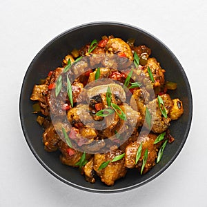 Mushrooms Manchurian dry in black bowl isolated at white background