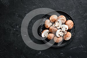 Mushrooms in a plate. Champignons on the old background. Top view.