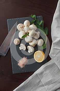 Mushrooms on slate board with lemon and mint