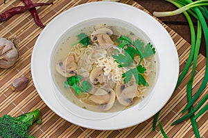Mushrooms soup with greens, garlic and parmesan cheese. Rustic style. Wooden rustic background. Top view