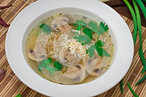 Mushrooms soup with greens, garlic and parmesan cheese. Rustic style. Wooden rustic background. Top view