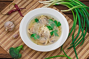 Mushrooms soup with greens, garlic and parmesan cheese. Rustic style. Wooden rustic background. Top view