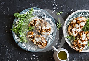 Mushrooms tartine. Baked sandwiches with mushrooms chanterelles and mozzarella on a dark background