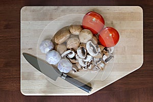 Mushrooms Tomatoes Garlic Cloves Kitchen Knife on Cutting Board